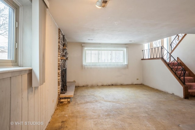 unfurnished room with stairs and a fireplace