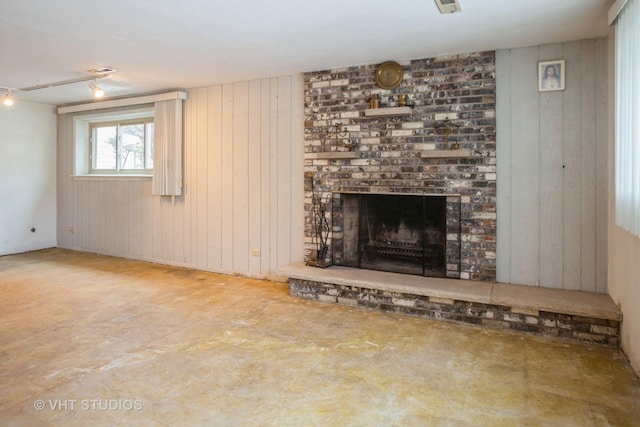 unfurnished living room featuring wood walls and a fireplace