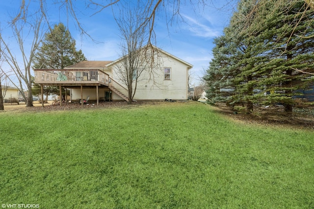 rear view of property featuring a wooden deck and a yard