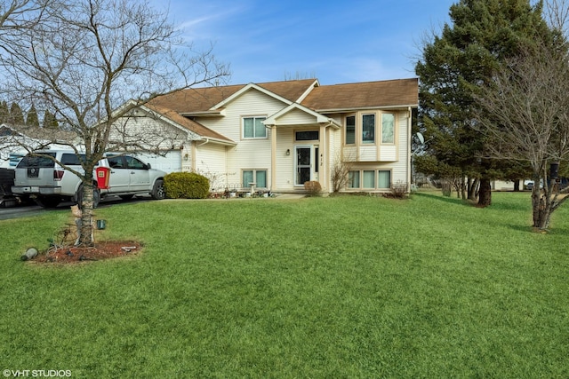 bi-level home featuring a garage and a front lawn