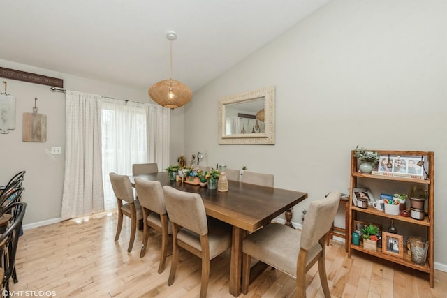 dining area with lofted ceiling and light hardwood / wood-style flooring