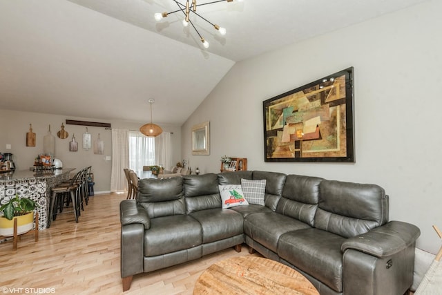 living room featuring a chandelier, vaulted ceiling, and light wood-type flooring