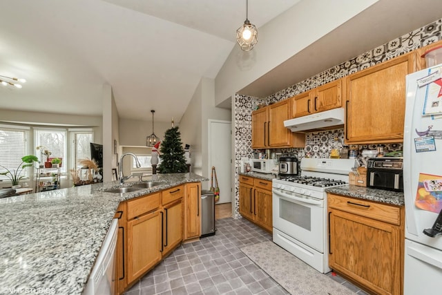 kitchen featuring sink, tasteful backsplash, pendant lighting, white appliances, and light stone countertops