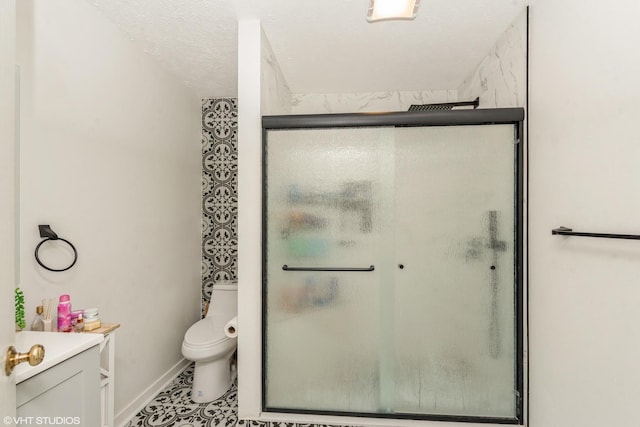 bathroom with walk in shower, vanity, toilet, and a textured ceiling