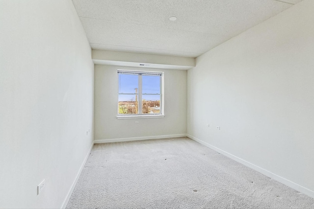 carpeted spare room with a textured ceiling