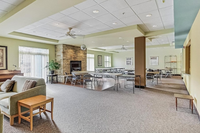 living room with ceiling fan, a raised ceiling, and carpet