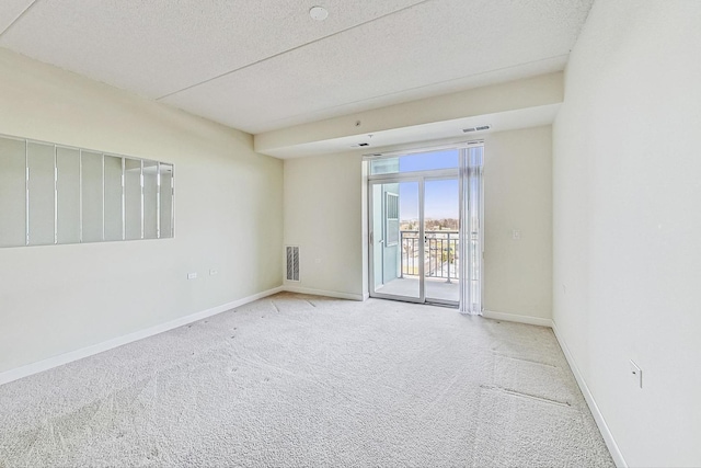 unfurnished room featuring light carpet and a textured ceiling