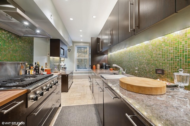 kitchen with decorative backsplash, wall chimney exhaust hood, stainless steel gas stovetop, a sink, and recessed lighting