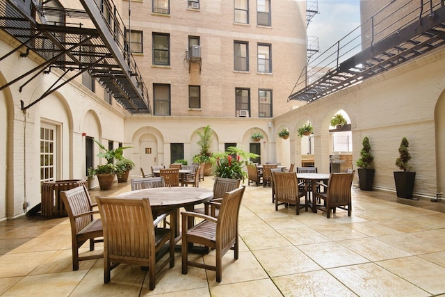 view of patio / terrace featuring outdoor dining area and a wall mounted air conditioner