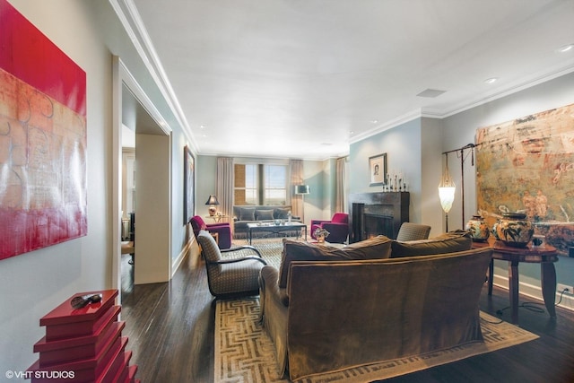 living area featuring crown molding, a fireplace, baseboards, and wood finished floors