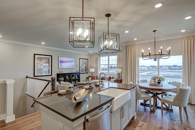 kitchen featuring stainless steel dishwasher, an island with sink, hanging light fixtures, and white cabinets