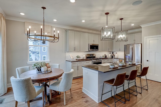 kitchen featuring pendant lighting, sink, light wood-type flooring, and appliances with stainless steel finishes