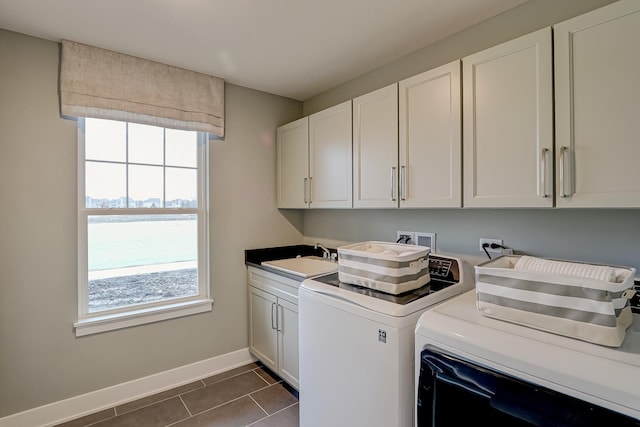 washroom featuring sink, cabinets, washing machine and clothes dryer, and dark tile patterned flooring