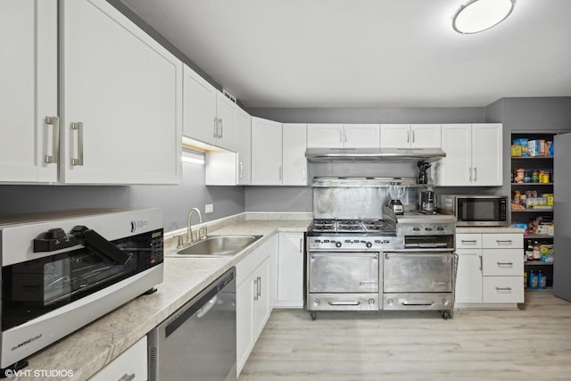 kitchen featuring sink, stainless steel appliances, white cabinets, and light wood-type flooring