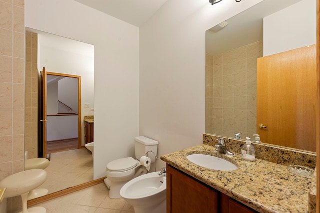 bathroom featuring a bidet, toilet, tile patterned floors, and vanity