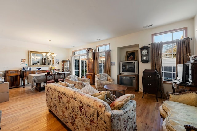 living room featuring an inviting chandelier and light wood-type flooring