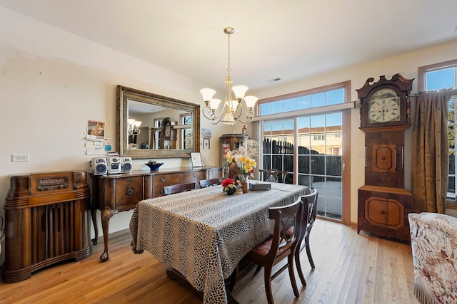 dining area featuring plenty of natural light, a notable chandelier, and light wood-type flooring