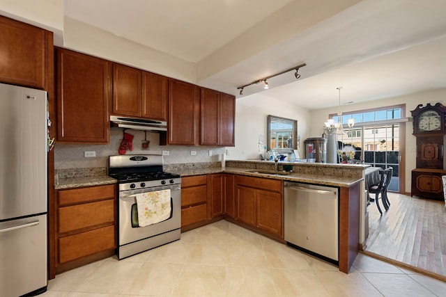 kitchen featuring sink, a notable chandelier, backsplash, and appliances with stainless steel finishes