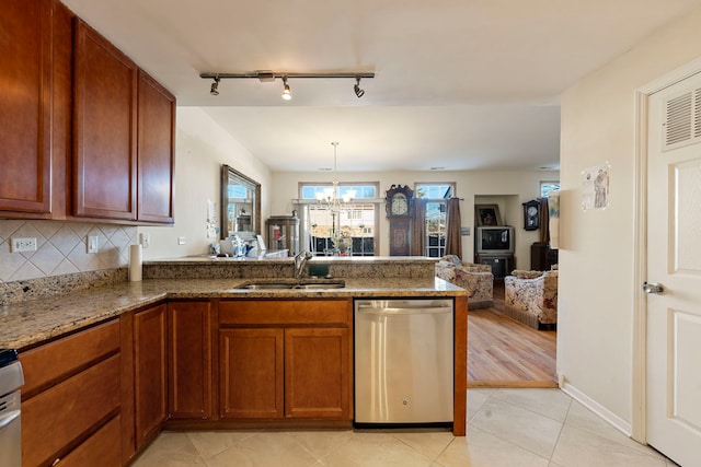 kitchen featuring sink, an inviting chandelier, dark stone countertops, dishwasher, and kitchen peninsula