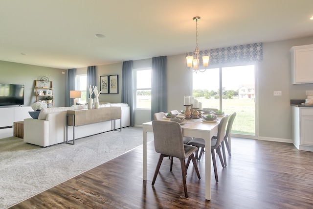 dining space with hardwood / wood-style floors and a notable chandelier