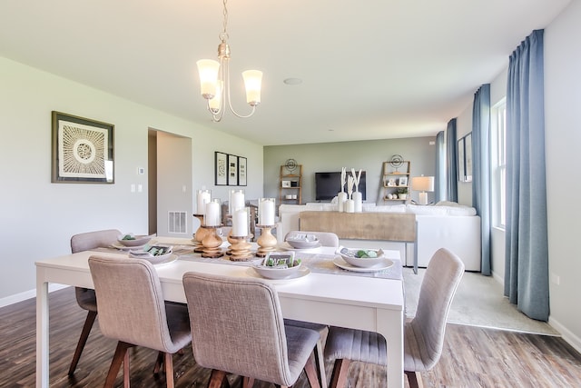 dining room with an inviting chandelier and light hardwood / wood-style flooring