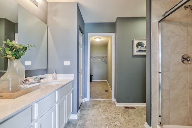 bathroom with a shower with door and vanity