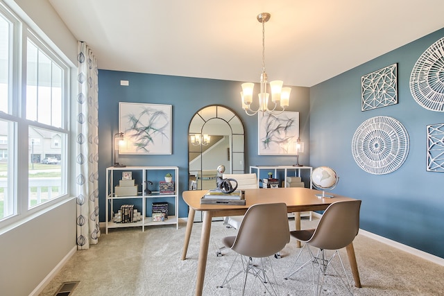 carpeted dining space featuring a notable chandelier