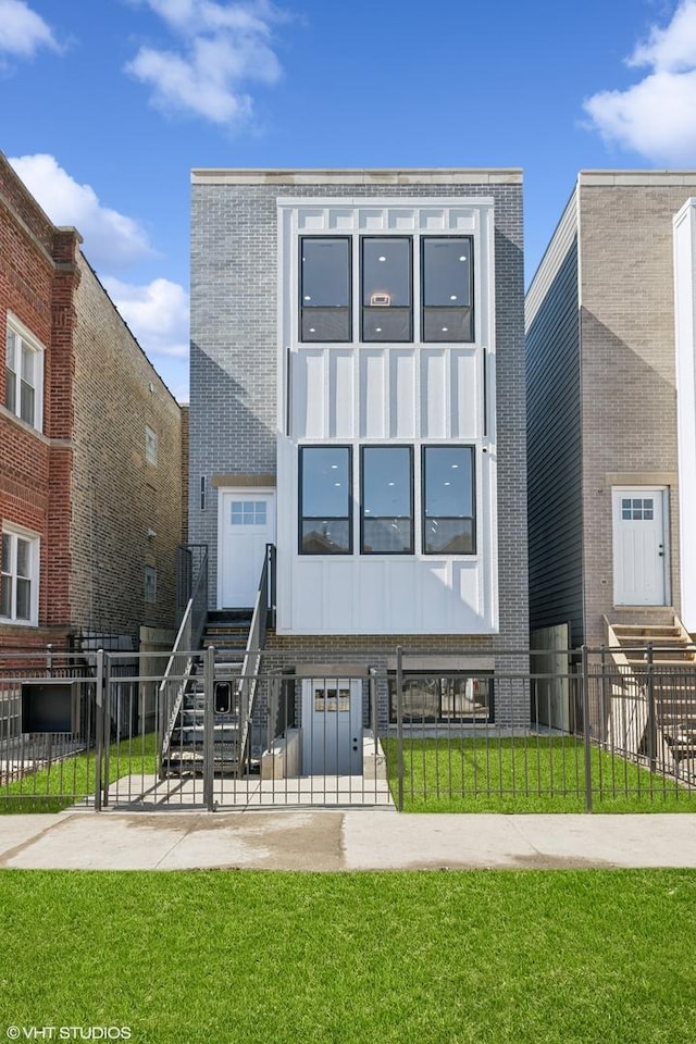 view of front of home featuring entry steps, brick siding, a fenced front yard, and a front yard