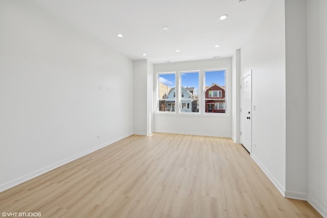 unfurnished room with light wood finished floors, baseboards, and recessed lighting