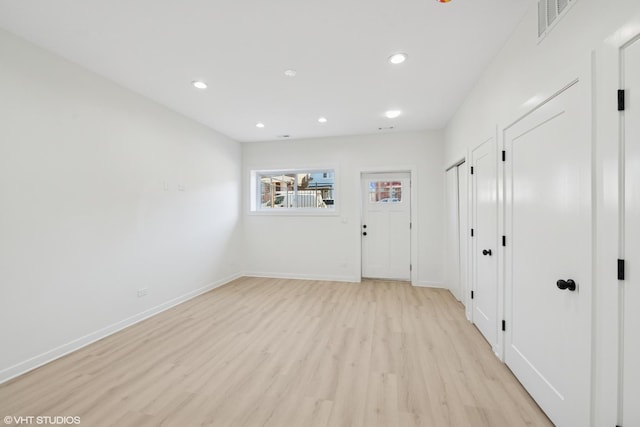 interior space featuring light wood-style floors, recessed lighting, visible vents, and baseboards