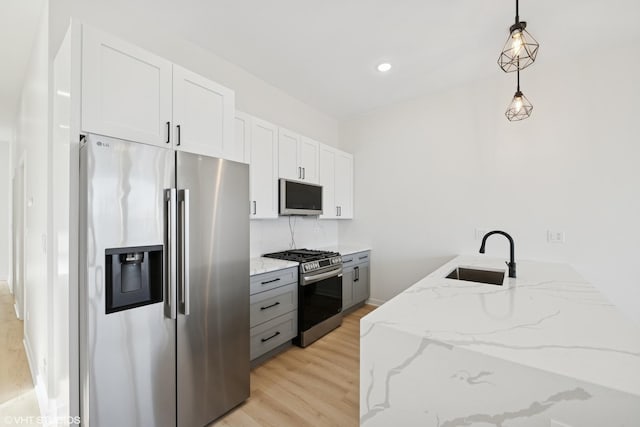 kitchen with tasteful backsplash, light stone counters, stainless steel appliances, light wood-type flooring, and a sink