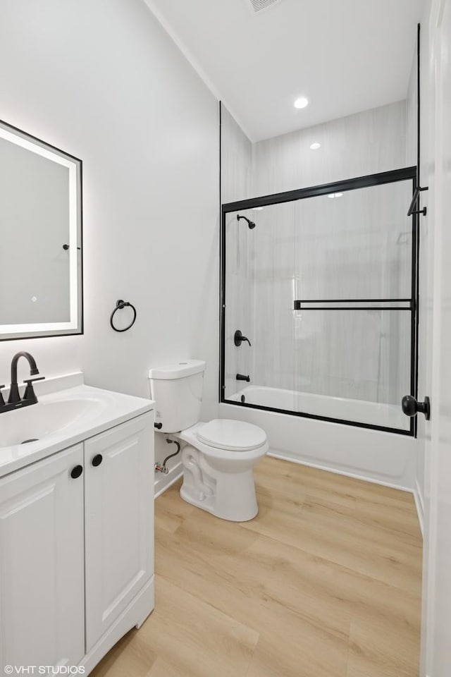 full bath with visible vents, toilet, enclosed tub / shower combo, vanity, and wood finished floors