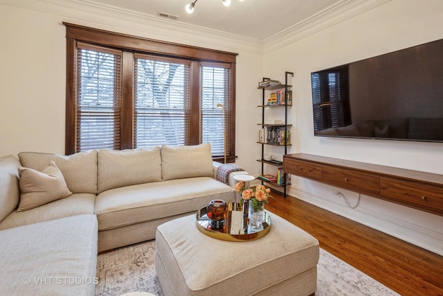 living room with crown molding and light wood-type flooring