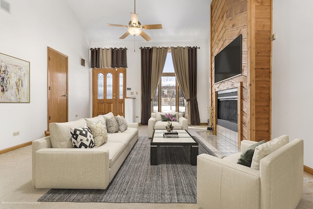 carpeted living room with high vaulted ceiling, a tile fireplace, and ceiling fan