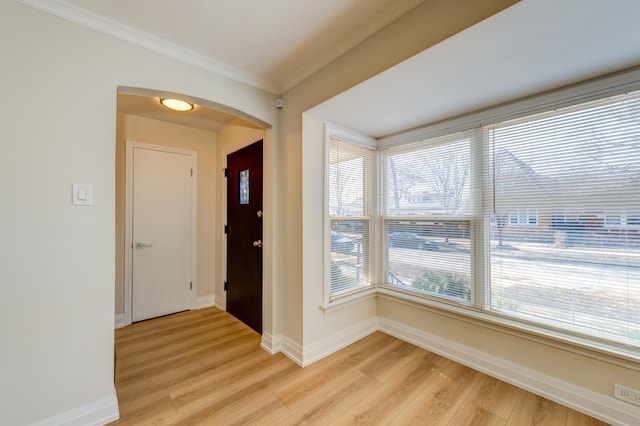 entryway featuring ornamental molding and light hardwood / wood-style floors