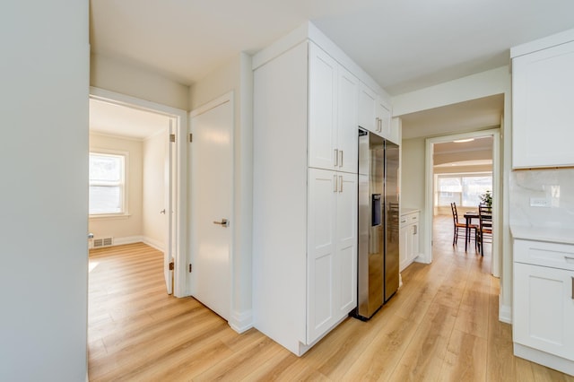 hall featuring plenty of natural light and light hardwood / wood-style floors