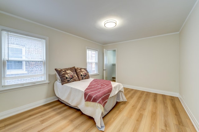 bedroom with ornamental molding and light wood-type flooring