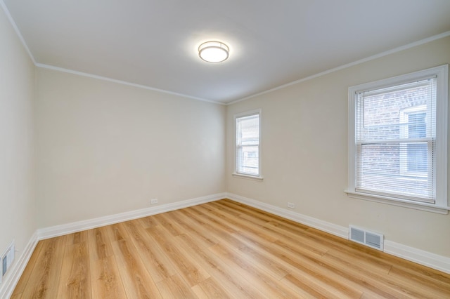 empty room featuring crown molding and light hardwood / wood-style flooring