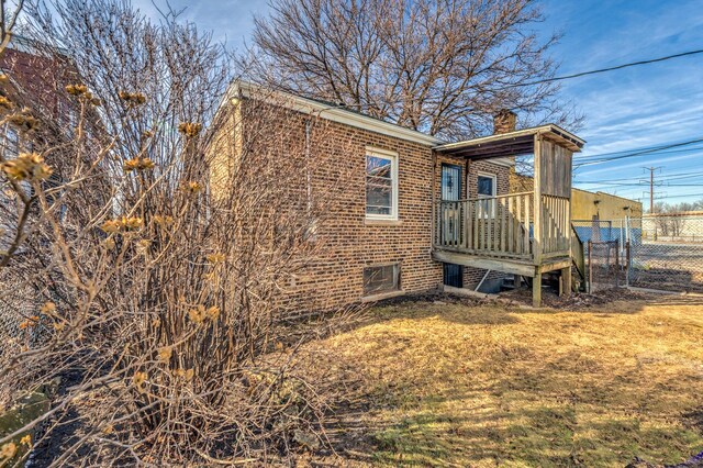 view of home's exterior with a lawn and a deck