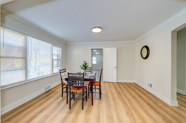 dining area featuring crown molding, plenty of natural light, and light wood-type flooring