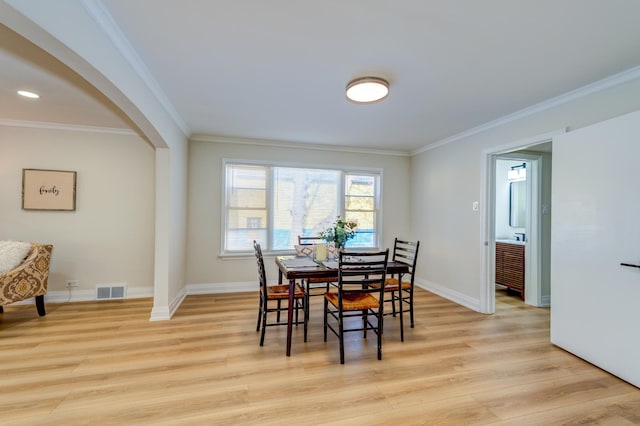 dining room featuring ornamental molding and light hardwood / wood-style flooring