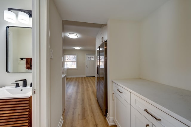 hallway featuring sink and light wood-type flooring