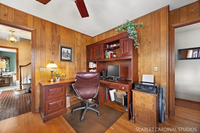 office with wooden walls, wood finished floors, and a ceiling fan