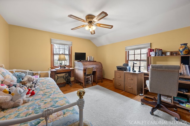 bedroom with light wood finished floors, multiple windows, lofted ceiling, and ceiling fan