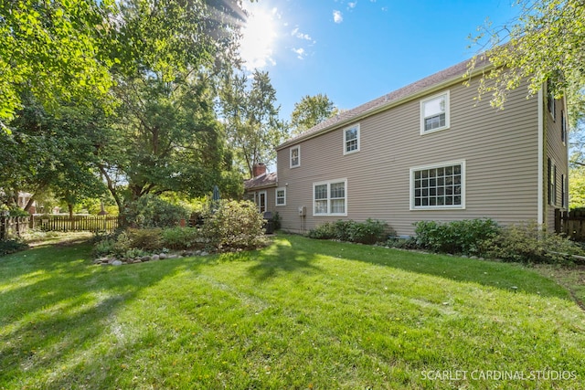 back of house featuring a yard and fence