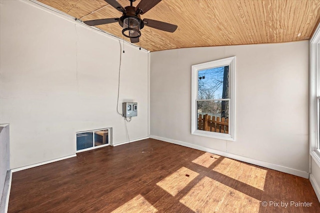 empty room with vaulted ceiling, wooden ceiling, wood finished floors, and baseboards