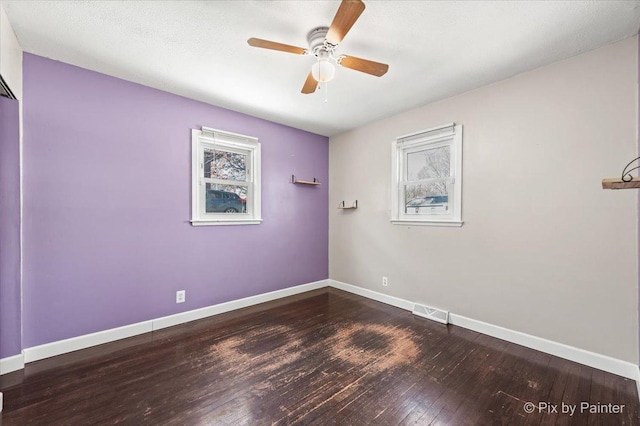 spare room featuring ceiling fan, hardwood / wood-style flooring, visible vents, and baseboards