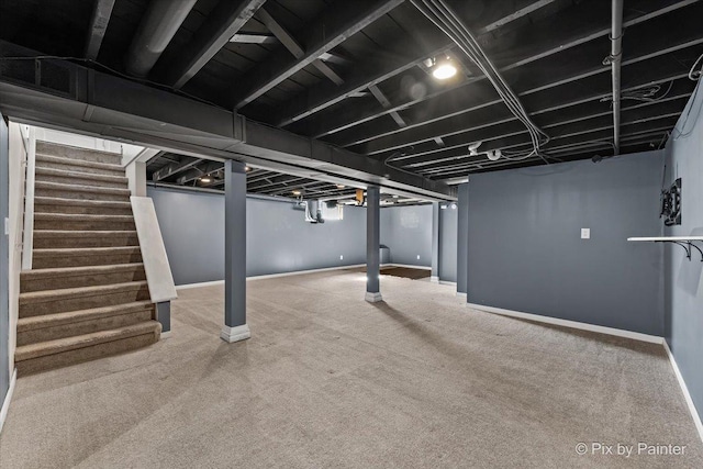 finished basement with carpet floors, stairway, and baseboards