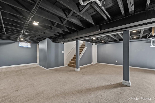 below grade area featuring stairs, carpet, and baseboards