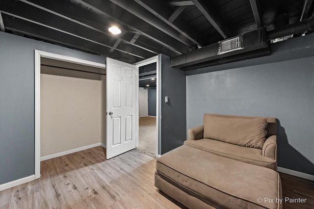 living area with visible vents, baseboards, and wood finished floors